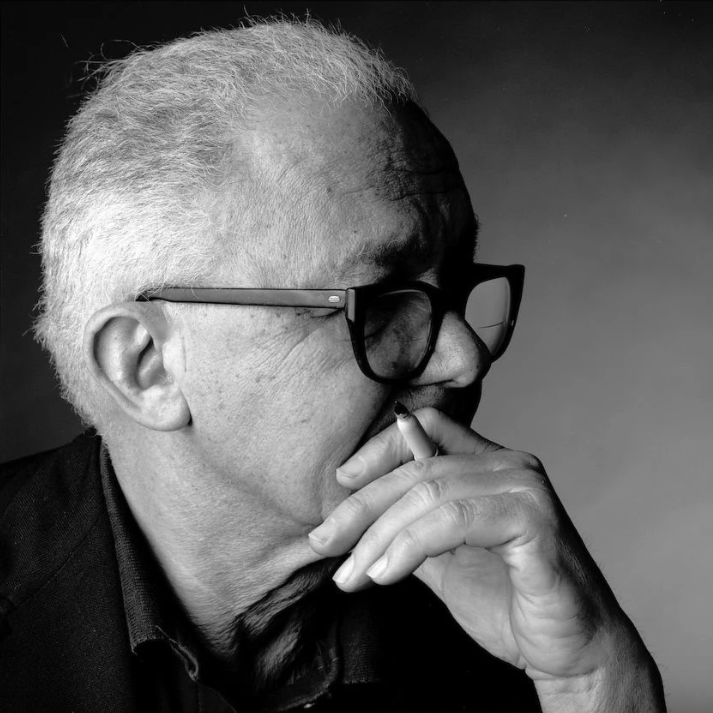 Portrait photograph of Paul Rand, a pioneering graphic designer, wearing formal attire against a neutral background in his professional studio setting